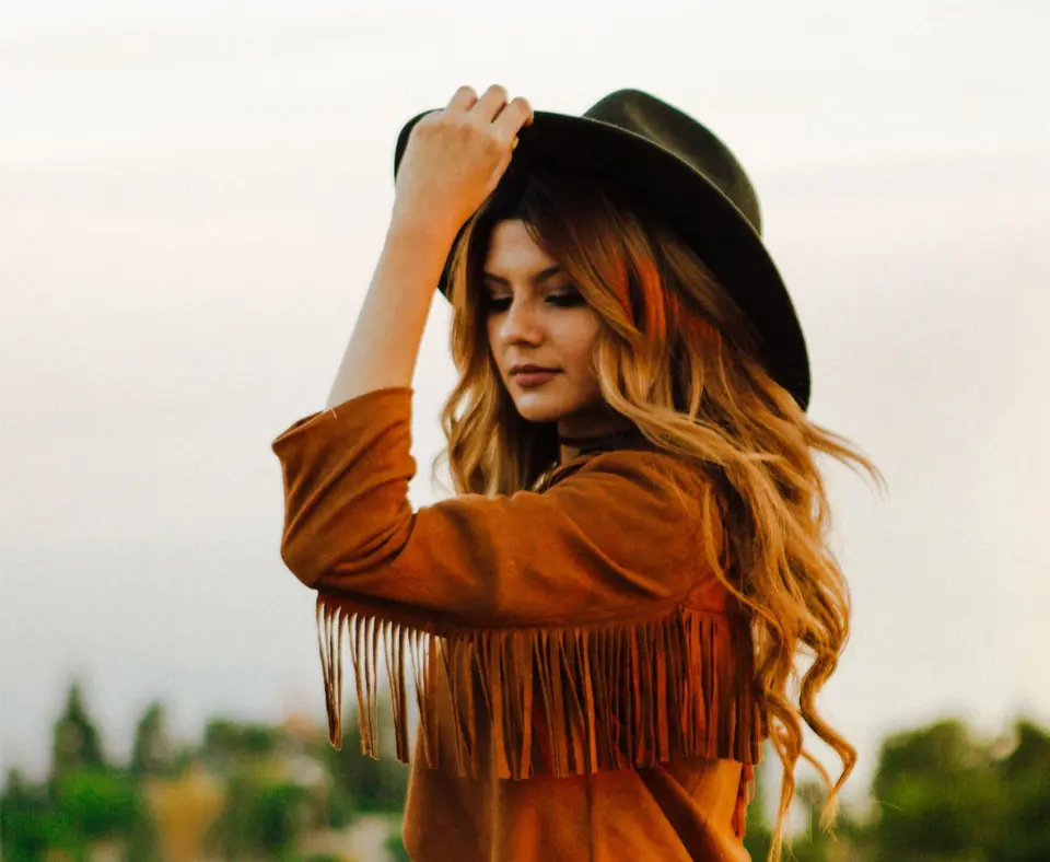 A woman with long hair wearing a hat.