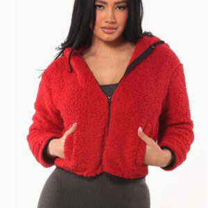 A woman wearing a red jacket and black top