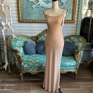 A mannequin wearing a dress in front of a couch.