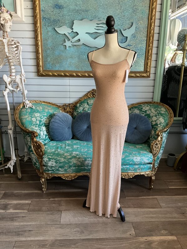 A mannequin wearing a dress in front of a couch.